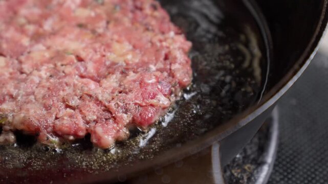 Homemade Burger Patty Sizzling in a Cast Iron Skillet