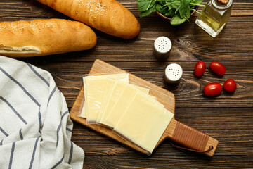 Naklejka premium Board with slices of delicious processed cheese, fresh tomatoes and bread on wooden table
