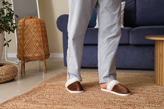 Legs of man wearing brown slippers at home