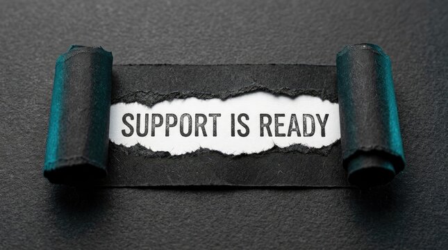 Support is ready text message revealed behind torn dark black paper roll with sharp contrast lighting