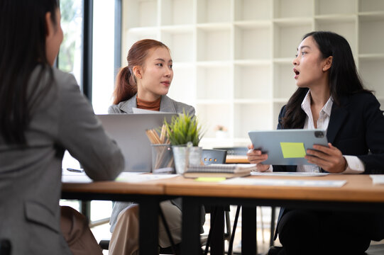 Business meeting with women discussing strategy using tablet and reports in office