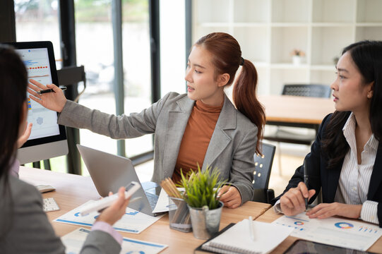 Business presentation with women reviewing data charts and analytics in modern office