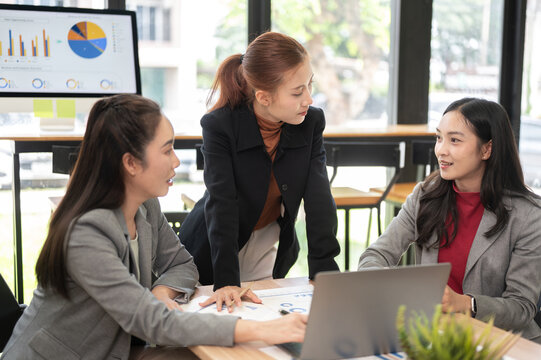 Business meeting with women collaborating on strategy around office table
