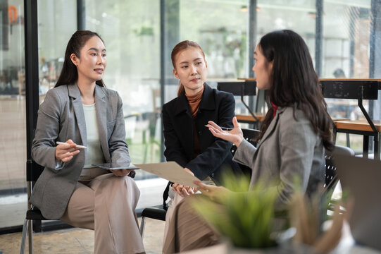 Business meeting with women reviewing a report and discussing strategy