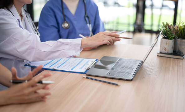 Healthcare team discussing medical documents and coordinating patient care