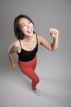 A woman in her 40s who enjoys fitness exercises with a smile and plenty of energy; she runs and does walking workouts to stay healthy and lose weight during menopause.