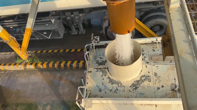 An industrial tanker fills from a high‑pressure overhead pipe at a refilling bay near EGA in Dubai&rsquo;s logistics zone.