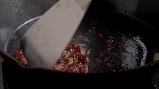 flipping hamburger patty, browning and crusty meat patty, home cooking concept