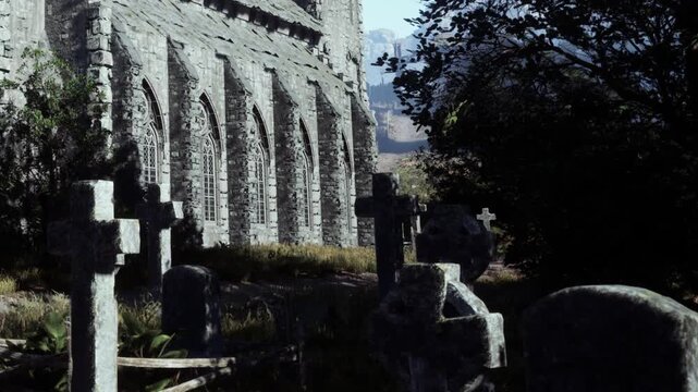 A stone structure stands in a cemetery filled with old gravestones. The setting is overgrown with grass and surrounded by trees. Mountains can be seen in the distance.