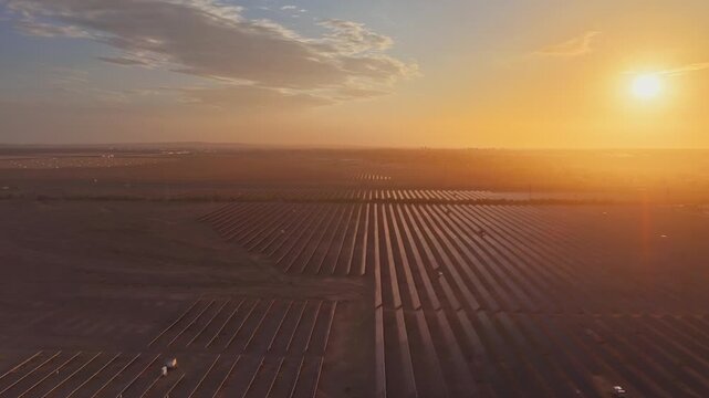 Solar photovoltaic panels at sunrise/sunset; wind turbine power plant; new energy