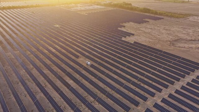 Solar photovoltaic panels at sunrise/sunset; wind turbine power plant; new energy
