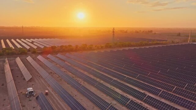 Solar photovoltaic panels at sunrise/sunset; wind turbine power plant; new energy