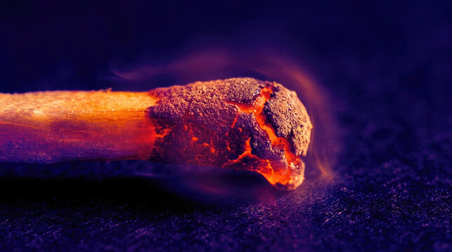 Burning match head with glowing embers and smoke, showcasing friction heating effects