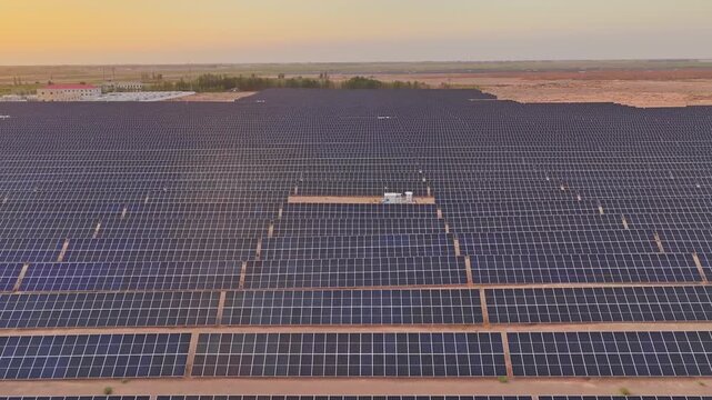 Solar photovoltaic panels at sunrise/sunset; wind turbine power plant; new energy