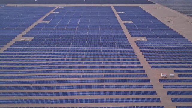 Solar photovoltaic panels at sunrise/sunset; wind turbine power plant; new energy