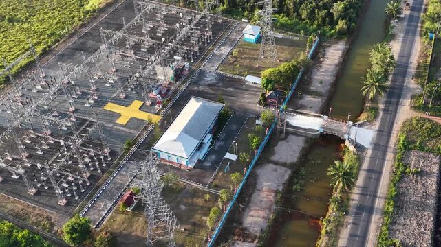 Aerial view of a power transformer station situated next to a rural road in Indonesia