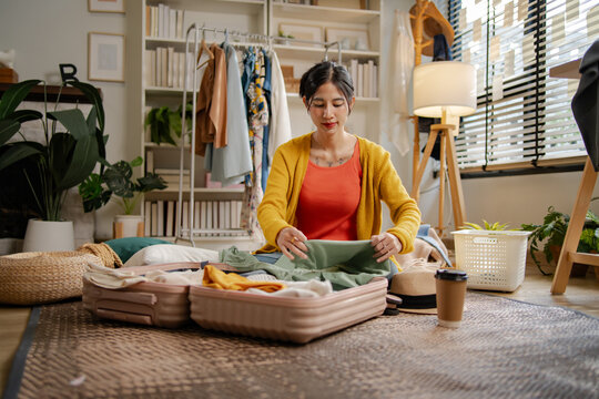 Asian woman using credit card for online hotel booking platform on laptop, representing creative professional women travel payment transaction, e-commerce shopping and holiday planning