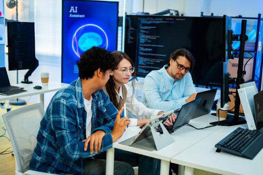 software developer talk strategy plan to executive write prompt AI bot IT app program data analytics in tech startup office.Projected visuals and glowing code on screen.AI chatbot technology concept