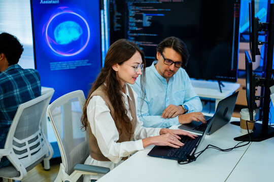 software developer talk strategy plan to executive write prompt AI bot IT app program data analytics in tech startup office.Projected visuals and glowing code on screen.AI chatbot technology concept