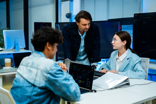software developer talk strategy plan to executive write prompt AI bot IT app program data analytics in tech startup office.Projected visuals and glowing code on screen.AI chatbot technology concept