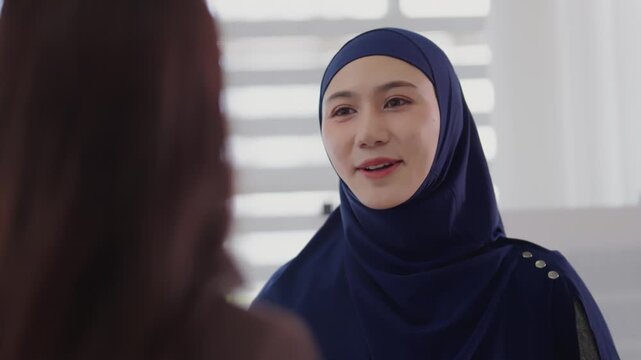 Two business colleagues multiethnic working in office, asian muslim