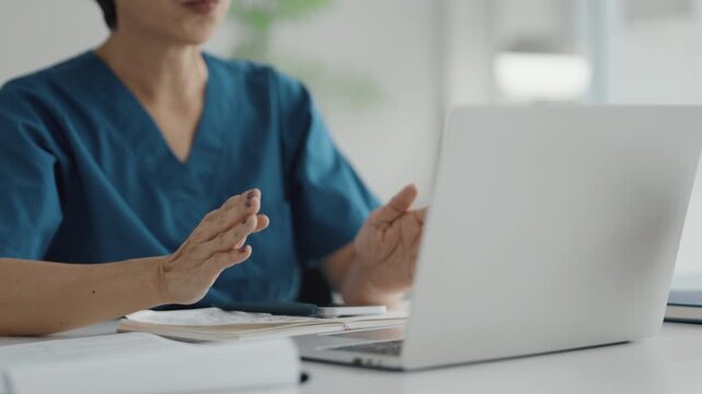 Doctor consults remotely via laptop in clinic office during advising call