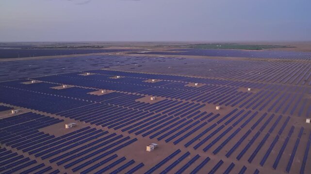 Solar photovoltaic panels at sunrise/sunset; wind turbine power plant; new energy