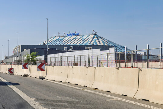 Antwerp, Belgium - 14 August 2026: Exterior view of the AFAS Dome venue building structure seen from road with traffic safety concrete barriers.