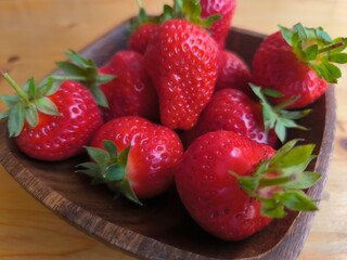 Strawberries in a wooden plate on the table © nicolas
