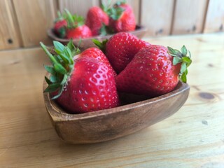 Strawberries in a wooden plate on the table © nicolas