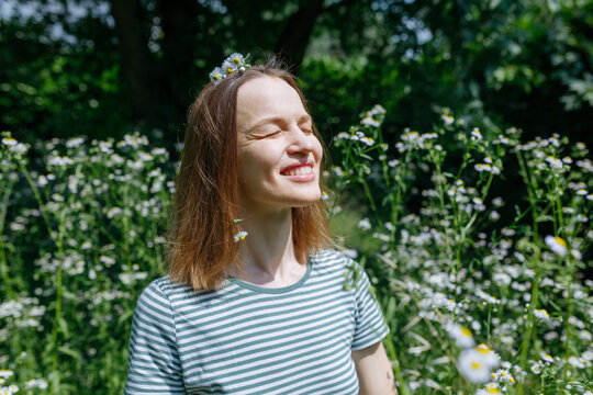 Smiling Woman Enjoying Summer Sunshine Among Wildflowers