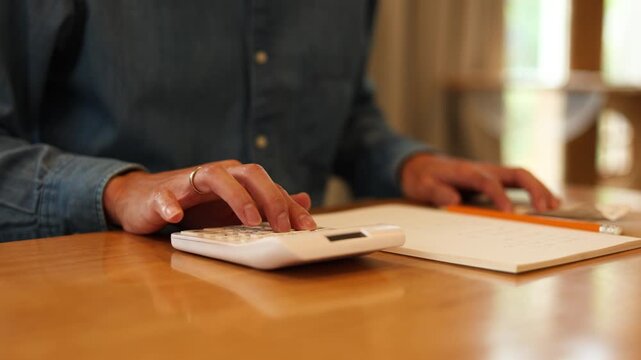 slow motion scene accountant man press on calculator to check about profit or budget and debt of company at office desk for business financial concept