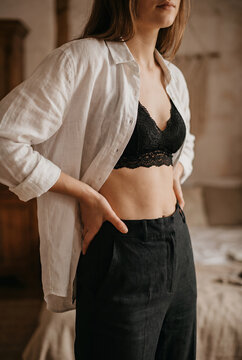 Woman in white shirt and black lace lingerie in minimalist interior