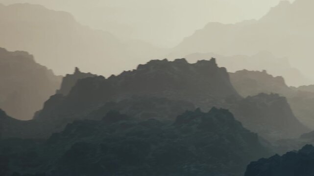 The scene shows layers of mountain silhouettes against a soft sky during dusk. The rock formations create a natural backdrop that fades into the distance.