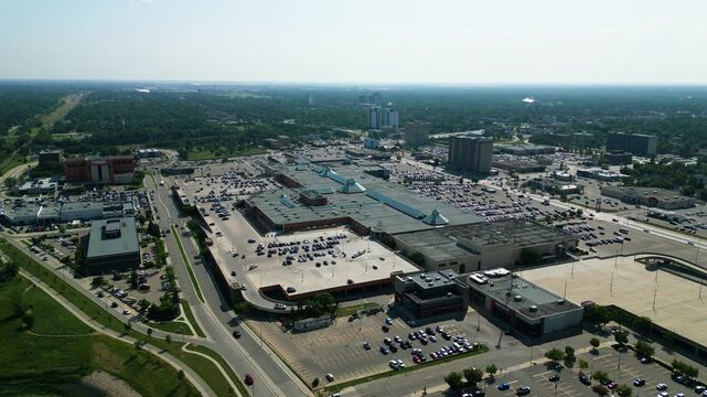 Static aerial drone shot of CF Polo Park and its surrounding parking areas, retail developments, and commercial district on a bright summer day.