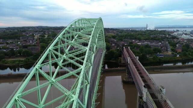 Silver Jubilee bridge aerial view as birds fly across the green arch landmark