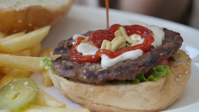 Making a burger with fries on a restaurant plate
