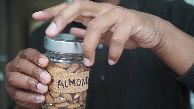 Holding a jar of almonds in a kitchen