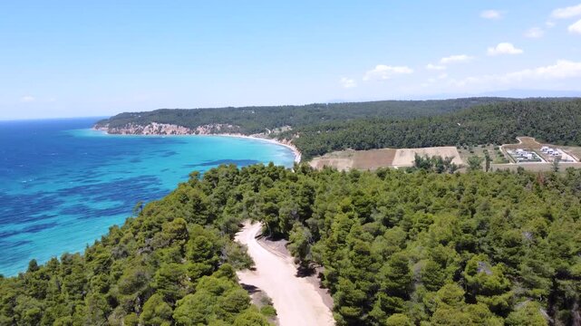 Scenic turquoise bay, rural farmland and pine covered coastline in Kassandra Halkidiki Greece, Aerial