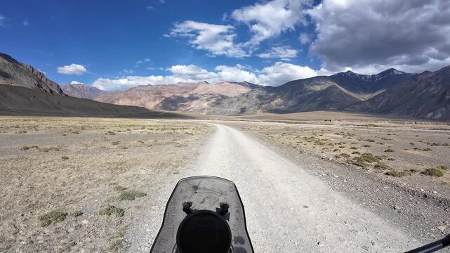 Padum, India : Point of view footage of motorcyclist ride on the off-road of Padum, high-altitude mountain road in Ladakh of India showing arid mountain range on sunny day