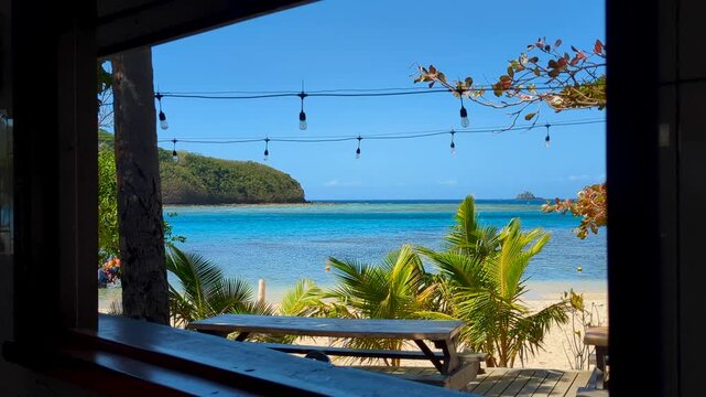 Scenic tropical island view through open window of white sand beach and turquoise ocean water in Yasawa Islands, Fiji