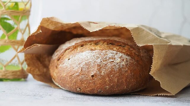 Fresh bread in a paper bag on a table
