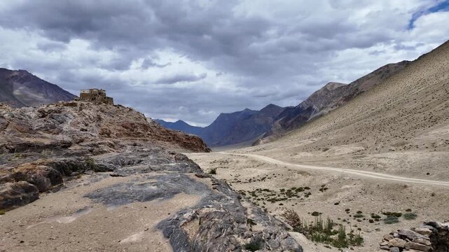 Zanskar, India : Panoramic footage of landscape and off road trail to Zangla palace, a hilltop fortress near Padum in Zanskar valley in Ladakh, India under dramatic cloudy sky during monsoon 