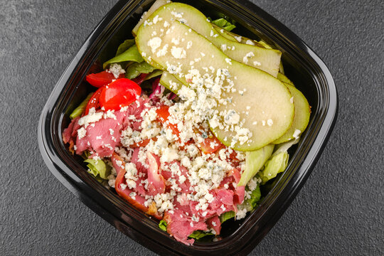 Healthy blue cheese and pear salad in white bowl for diet or fitness meal concept