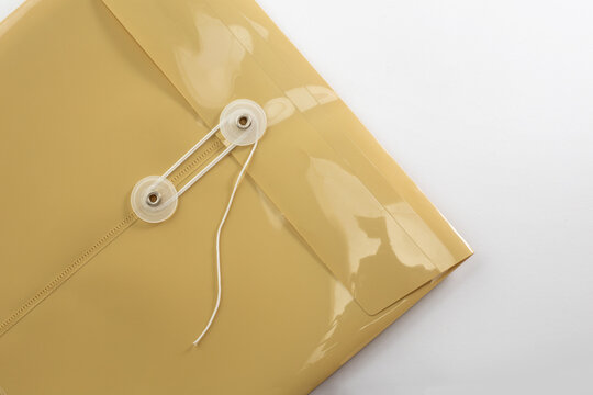 Yellow string tie plastic document folder envelope close up isolated on white background