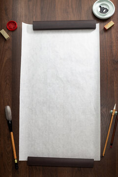 Blank Chinese calligraphy rice paper mockup on dark wooden background with ink, brushes, and seals top view