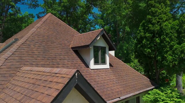 Residential roof gable with weathered wooden fascia and trim showing peeling paint and exterior wear. Home roof detail highlighting the need for maintenance and renovation