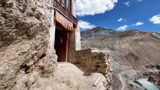 Zanskar, India : Tilt down footage reveals the tsarap river in Lungnak valley where Phuktal gompa, cliffside monastery built in natural cave of Zanskar in Ladakh, India surrounded by arid mountain 