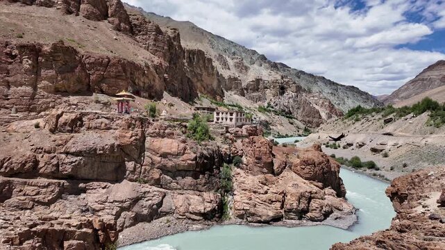 Zanskar, India : Panoramic footage of tsarap river in Lungnak valley with Phuktal gompa in the background, cliffside monastery built in natural cave of Zanskar in Ladakh in northern India 