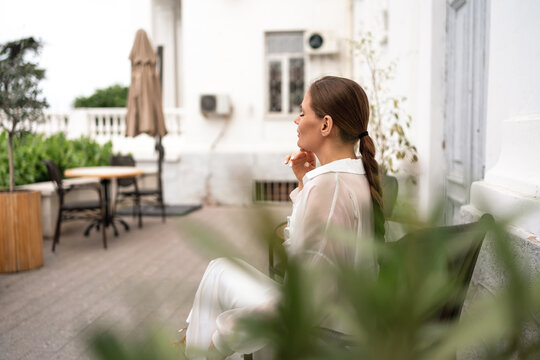 Serene woman resting on sunlit patio during peaceful daytime break in outdoor setting